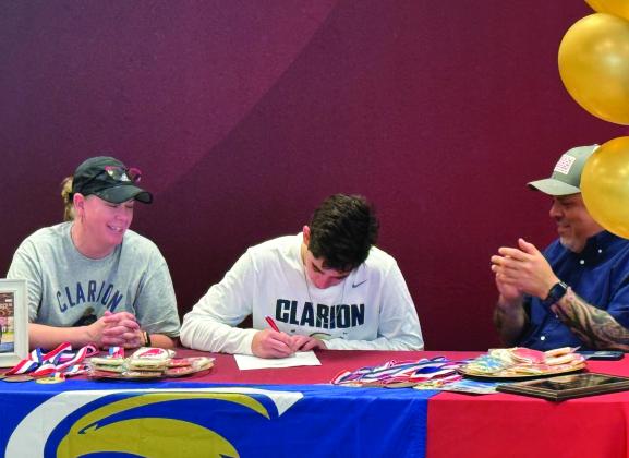 Ethan Coronado signs his letter of intent to dive at Clarion University with his parents by his side on Wednesday afternoon at Stanton High School.